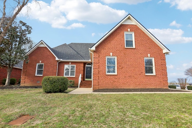 traditional-style home featuring crawl space, brick siding, roof with shingles, and a front yard