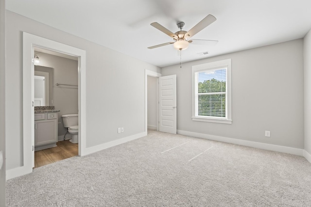 unfurnished bedroom with carpet flooring, ensuite bath, visible vents, and baseboards