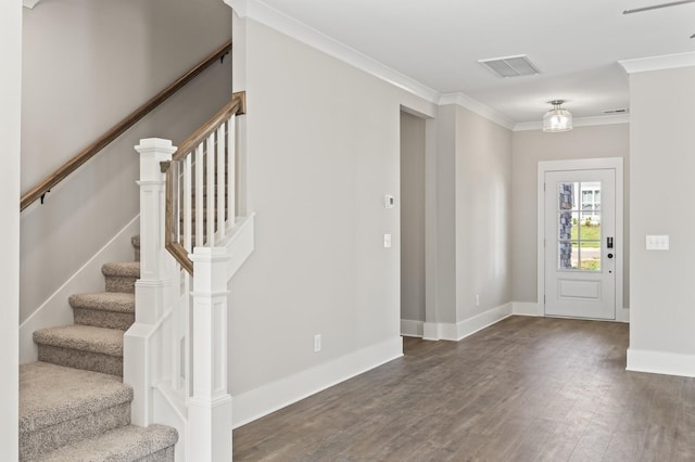 entryway featuring dark wood-style flooring, visible vents, baseboards, ornamental molding, and stairway