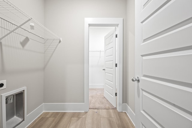 laundry room featuring wood finish floors, laundry area, hookup for an electric dryer, and baseboards