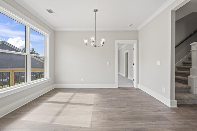 unfurnished dining area featuring stairs, baseboards, wood finished floors, and crown molding