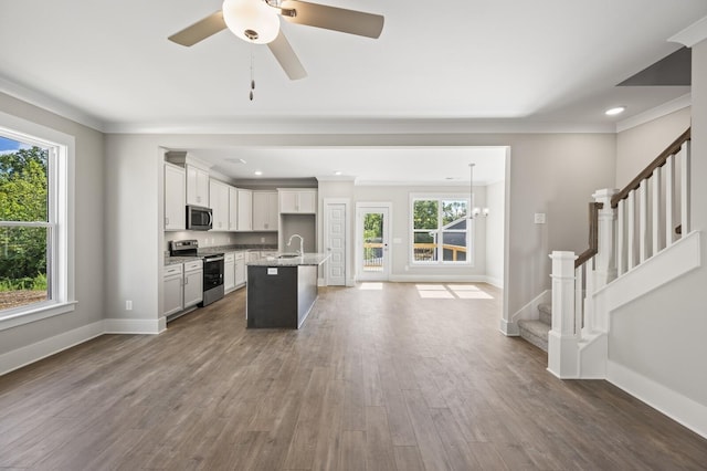 kitchen featuring a sink, baseboards, appliances with stainless steel finishes, dark wood-style floors, and crown molding