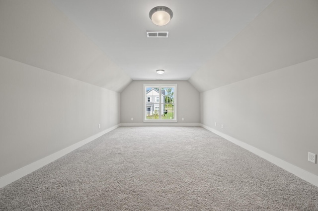 bonus room featuring carpet floors, lofted ceiling, visible vents, and baseboards