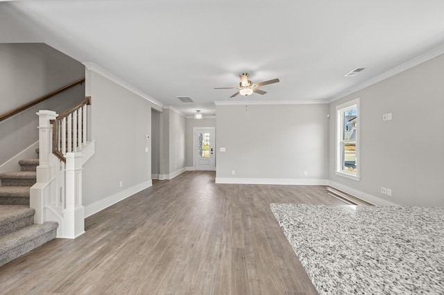 unfurnished living room featuring light wood-type flooring, visible vents, and ornamental molding