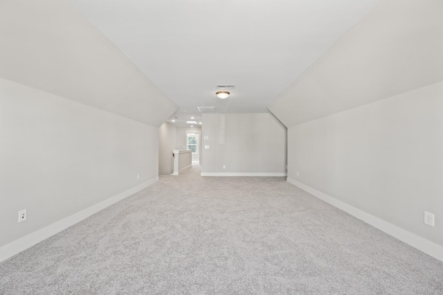 bonus room featuring carpet floors, visible vents, vaulted ceiling, and baseboards