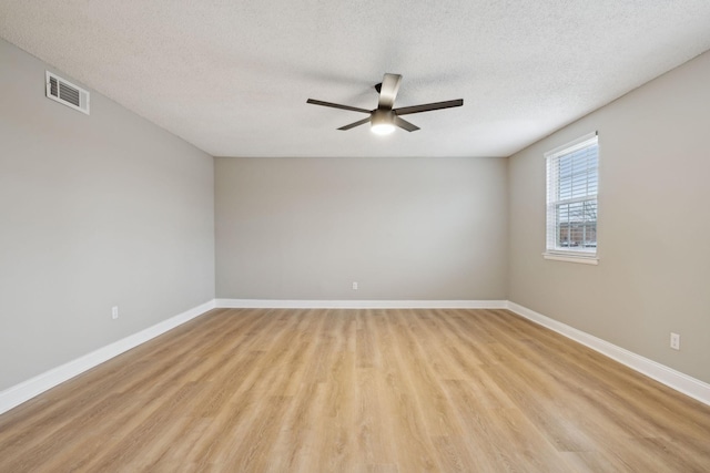 unfurnished room with light wood-style flooring, visible vents, and baseboards