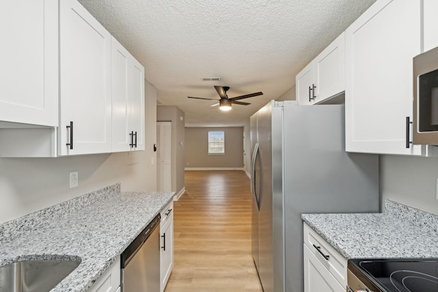 kitchen with ceiling fan, white cabinetry, visible vents, and stainless steel appliances