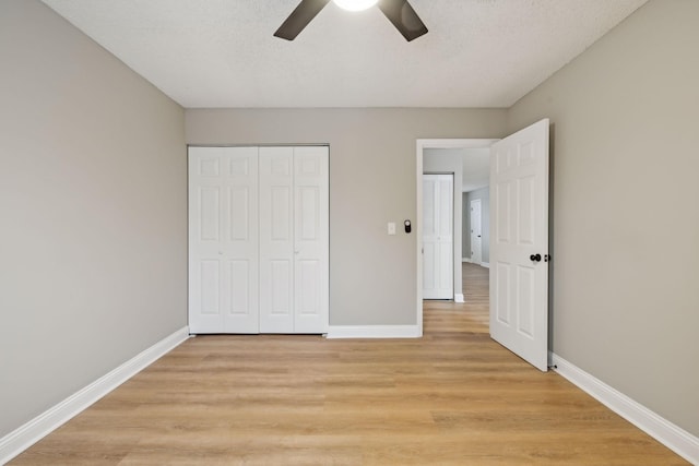 unfurnished bedroom with light wood-style flooring, baseboards, and a closet