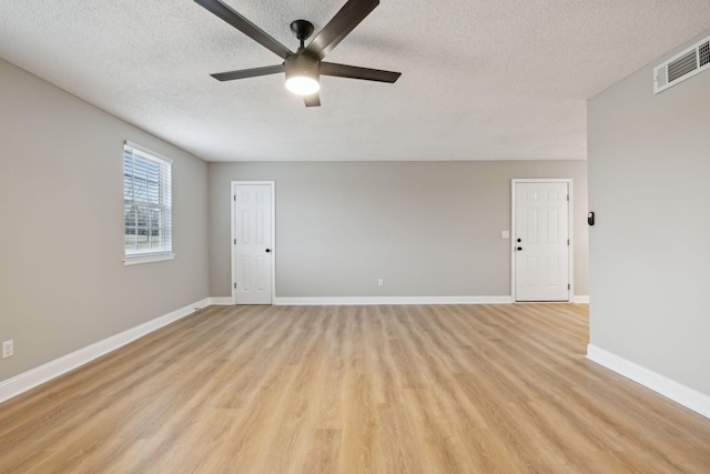 unfurnished room featuring baseboards, visible vents, a ceiling fan, a textured ceiling, and light wood-type flooring