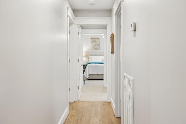 hallway with light wood-type flooring and visible vents