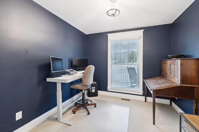 carpeted office with lofted ceiling and baseboards