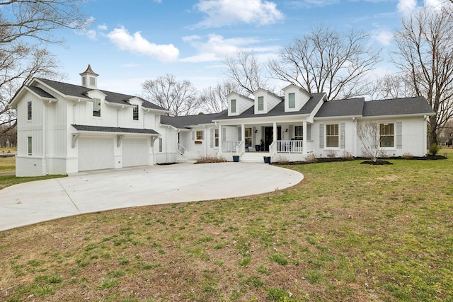 view of front of home featuring covered porch, concrete driveway, an attached garage, board and batten siding, and a front yard