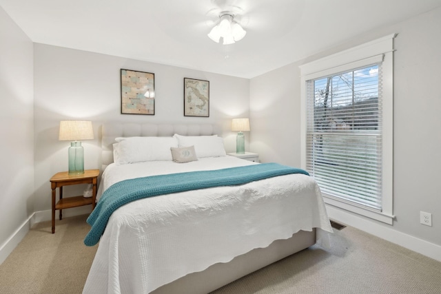 carpeted bedroom featuring visible vents, ceiling fan, and baseboards