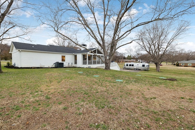 view of yard with a sunroom and central air condition unit