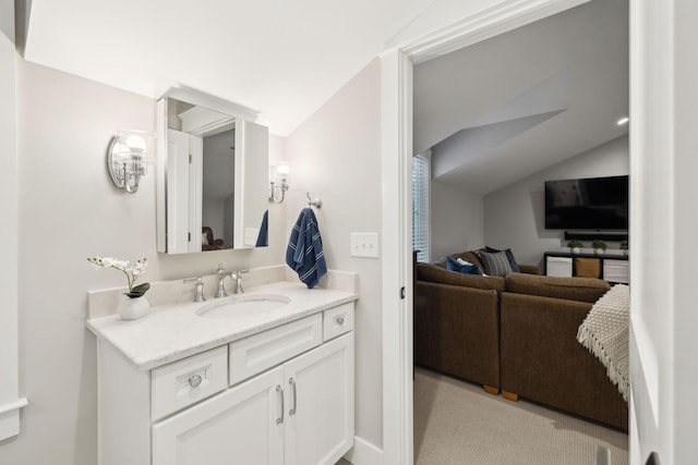 bathroom with lofted ceiling and vanity