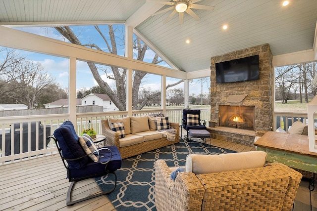 sunroom featuring an outdoor stone fireplace and vaulted ceiling