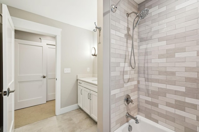 bathroom with baseboards, tub / shower combination, and vanity