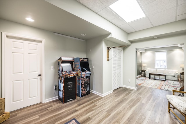 office featuring wood finished floors, a paneled ceiling, and baseboards