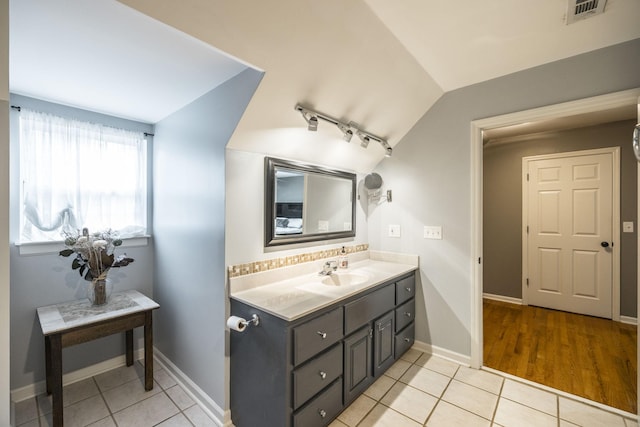 bathroom with lofted ceiling, vanity, tile patterned flooring, and visible vents