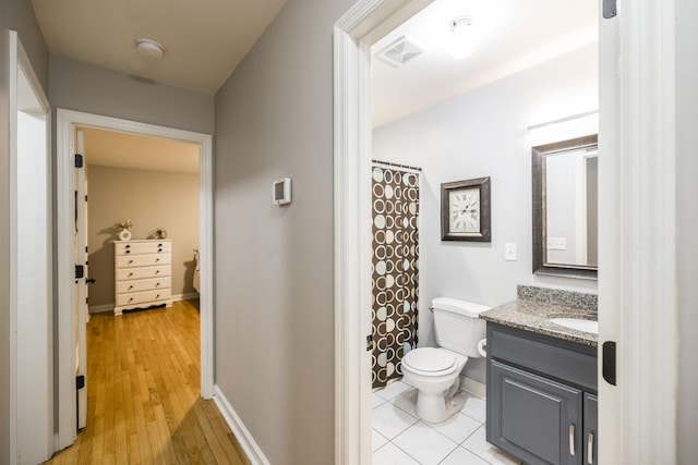 bathroom featuring toilet, baseboards, visible vents, and vanity