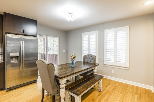 dining space featuring baseboards and light wood-style floors