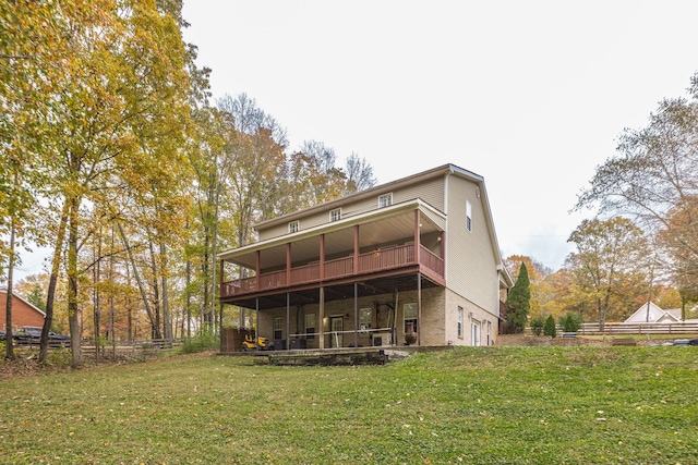 back of property with a lawn, fence, and a wooden deck