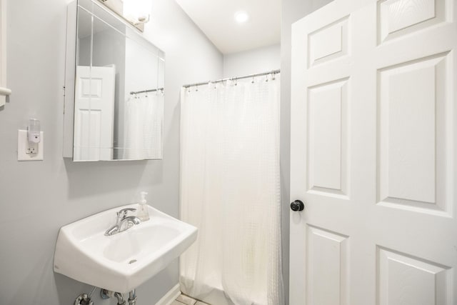 bathroom with a shower with curtain and a sink