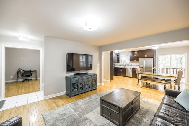 living room with light wood-type flooring and baseboards