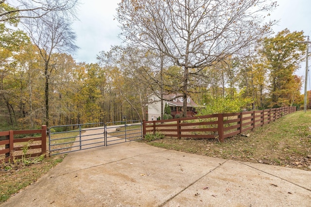 exterior space featuring a wooded view and fence