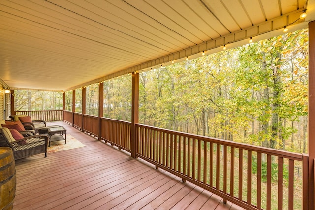 deck with an outdoor hangout area and a wooded view