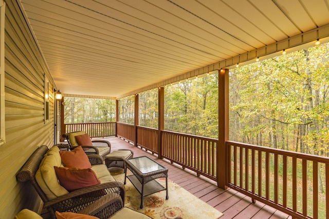 wooden deck featuring an outdoor living space and a forest view