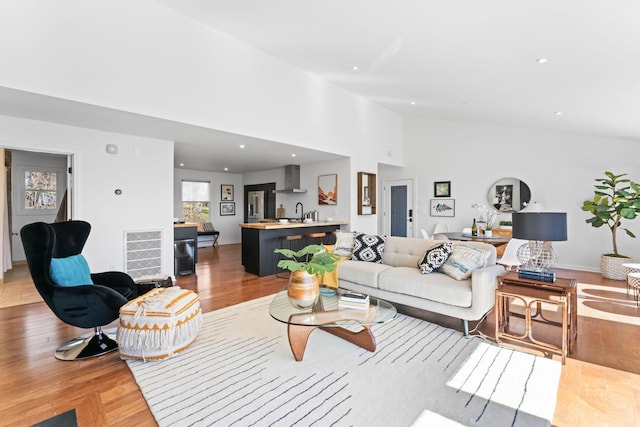 living room with light wood-type flooring, visible vents, and recessed lighting