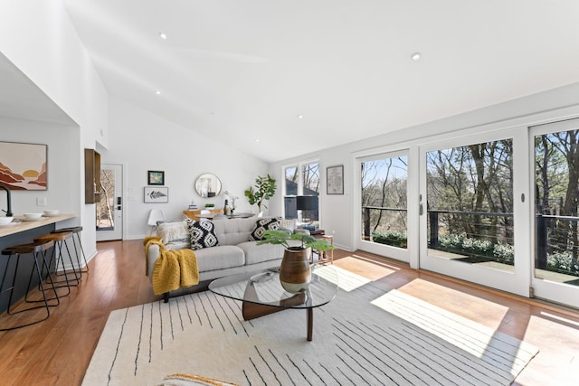 living area with high vaulted ceiling, recessed lighting, baseboards, and hardwood / wood-style floors