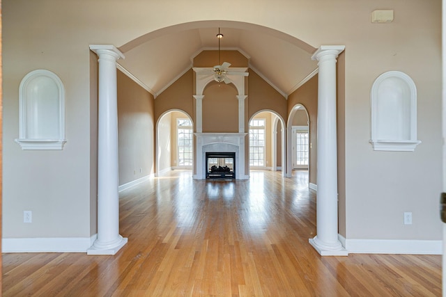 unfurnished living room featuring light wood-type flooring, a multi sided fireplace, ceiling fan, and ornate columns