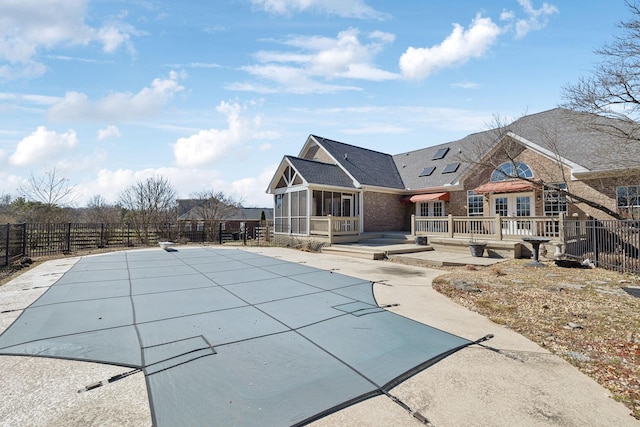 view of pool with a sunroom, a patio, a deck, and fence