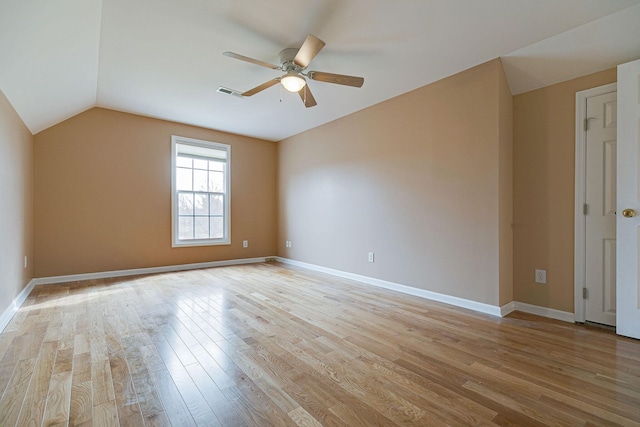 interior space with light wood-style flooring, visible vents, baseboards, vaulted ceiling, and a ceiling fan