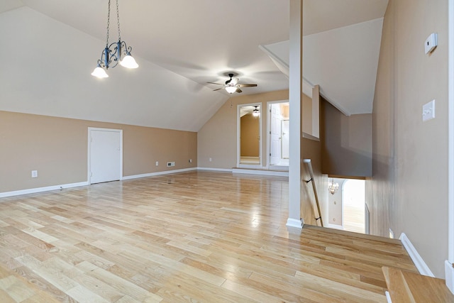 additional living space featuring vaulted ceiling, ceiling fan with notable chandelier, baseboards, and light wood-style floors