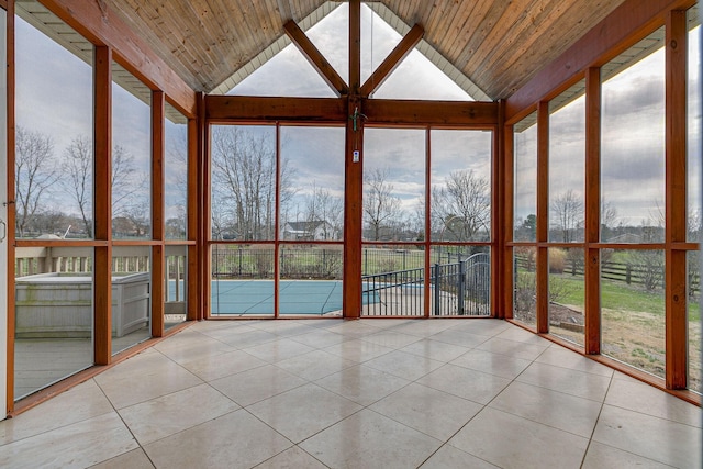 unfurnished sunroom featuring lofted ceiling, wooden ceiling, and a healthy amount of sunlight