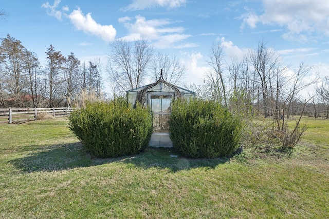 view of yard featuring fence and an outbuilding