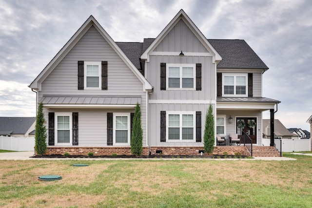 modern farmhouse featuring roof with shingles, board and batten siding, a front yard, a standing seam roof, and crawl space