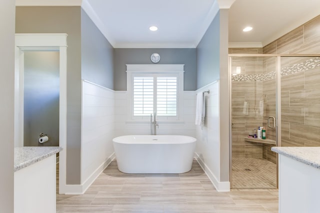 full bathroom with a freestanding bath, ornamental molding, a stall shower, and tile walls