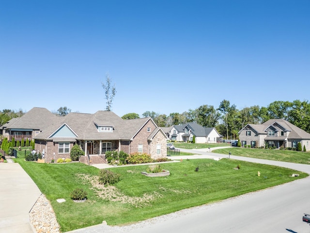 view of front of home with a residential view, brick siding, and a front lawn