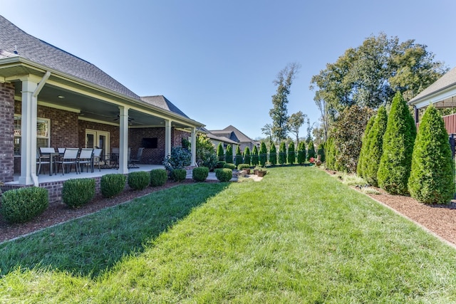 view of yard featuring a patio area, ceiling fan, and fence