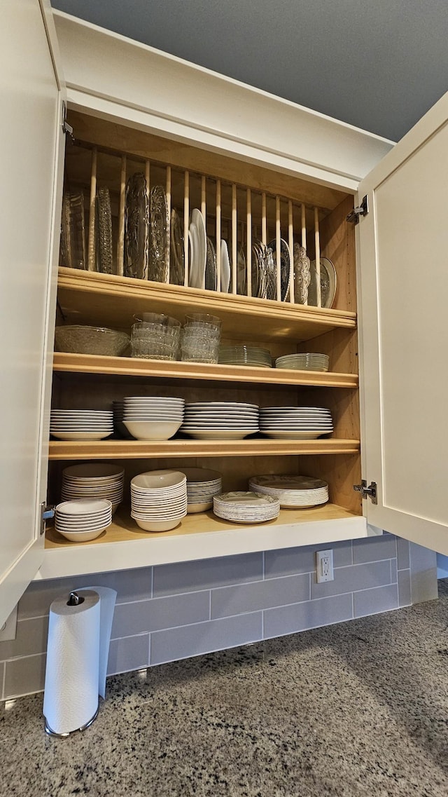 interior details with light stone countertops, white cabinets, and open shelves