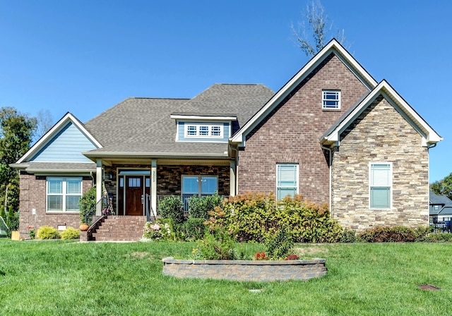 craftsman-style home featuring a front lawn, roof with shingles, and brick siding