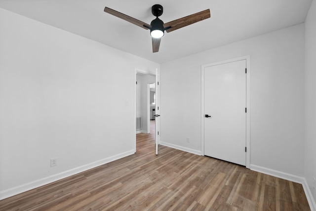 unfurnished bedroom with ceiling fan, visible vents, baseboards, and wood finished floors