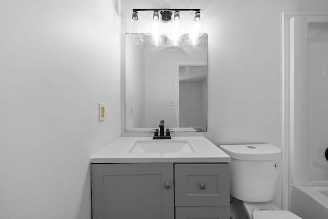 bathroom featuring tub / shower combination, vanity, and toilet