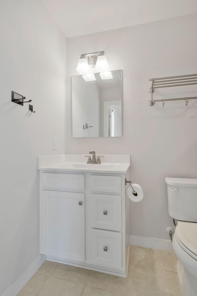 half bath featuring toilet, tile patterned floors, baseboards, and vanity