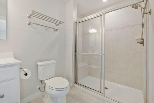 bathroom featuring a stall shower, tile patterned flooring, vanity, and toilet