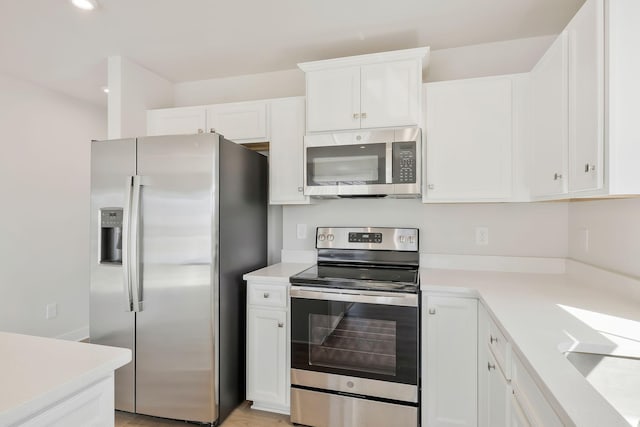 kitchen with white cabinets, stainless steel appliances, light countertops, and recessed lighting